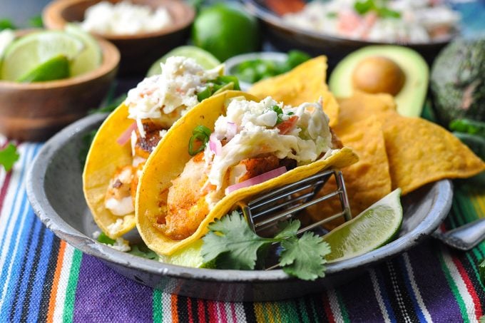 fish tacos on a festive decorated table with toppings