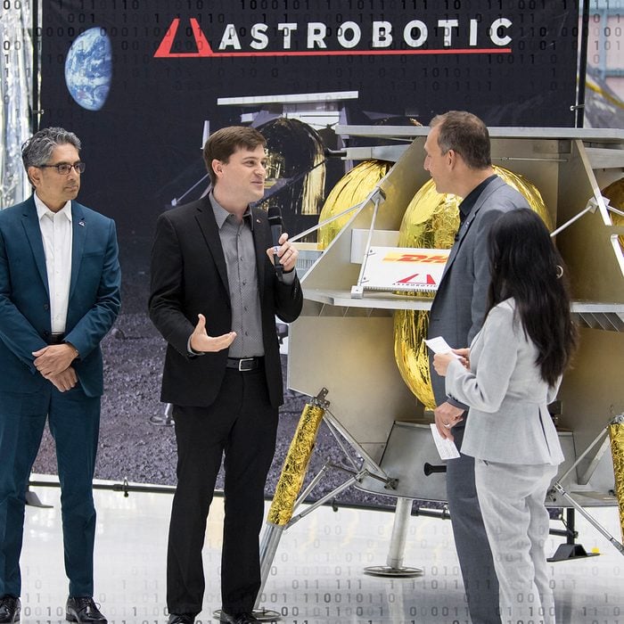 GREENBELT, MARYLAND - MAY 31: In this handout provided by the National Aeronautics and Space Administration (NASA), NASA Associate Administrator, Science Mission Directorate, Thomas Zurbuchen, second from right, speaks to Astrobotic CEO, John Thornton, second from left, and Astrobotic Mission Director, Sharad Bhaskaran, left, about their lunar lander, May 31, 2019, at Goddard Space Flight Center in Maryland. Astrobotic, Intuitive Machines, and Orbit Beyond have been selected to provide the first lunar landers for the Artemis program's lunar surface exploration. (Photo by Aubrey Gemignani-NASA/Getty Images)