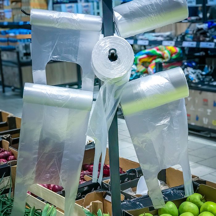 Plastic cellophane bags hanging on the stand in the supermarket fruits - vegetables department.