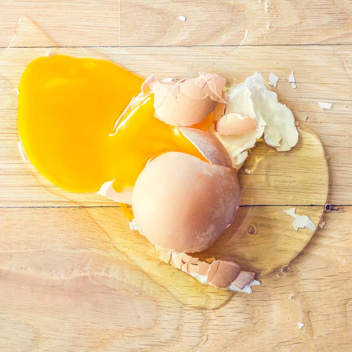 Broken egg on a wooden floor.