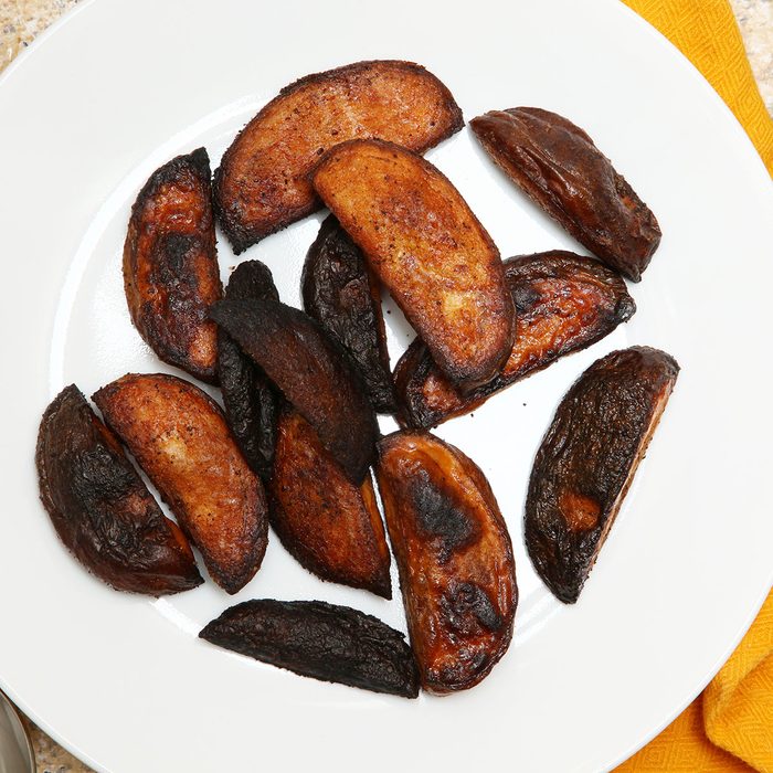 Burnt Potato Wedges in a plate on a table.