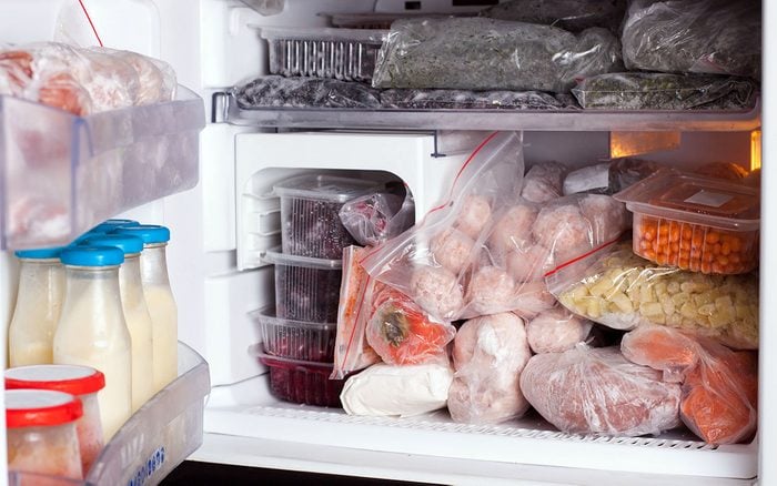 Refrigerator with frozen food (meat, milk, vegetables)