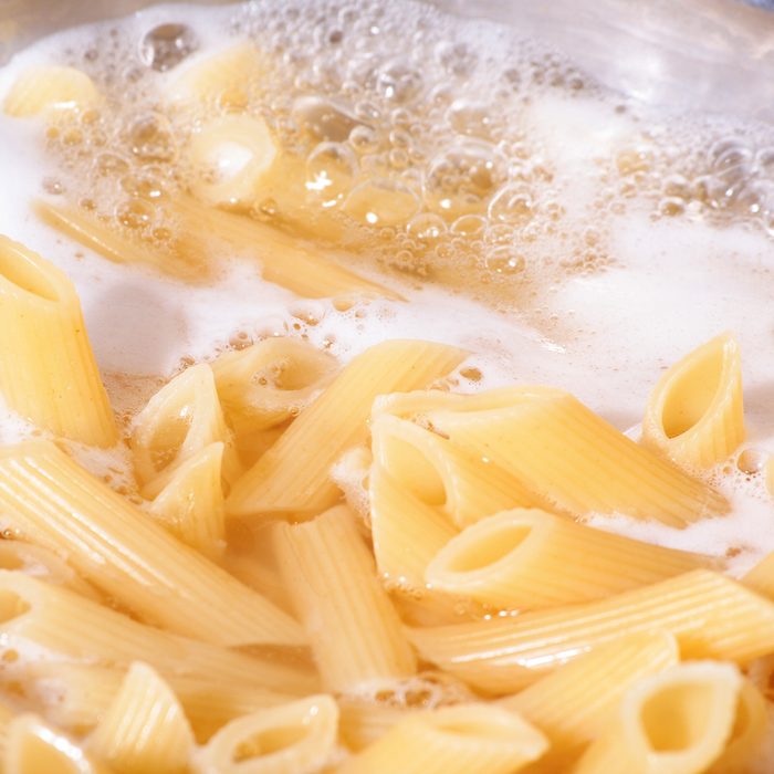 Cooking pasta. Penne boiling in the hot water.