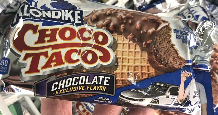 man holding choco taco in wrappper