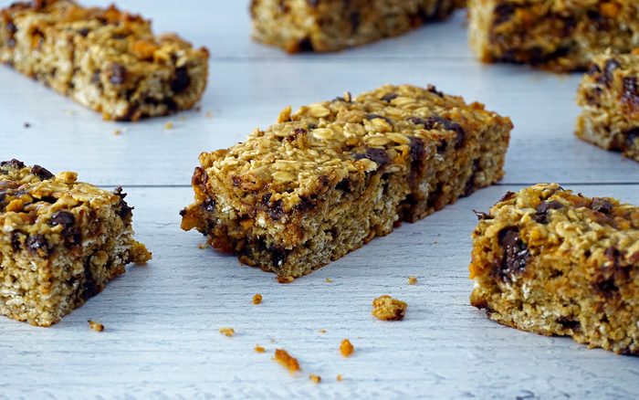 baked gluten-free granola bars scattered on weathered white wood