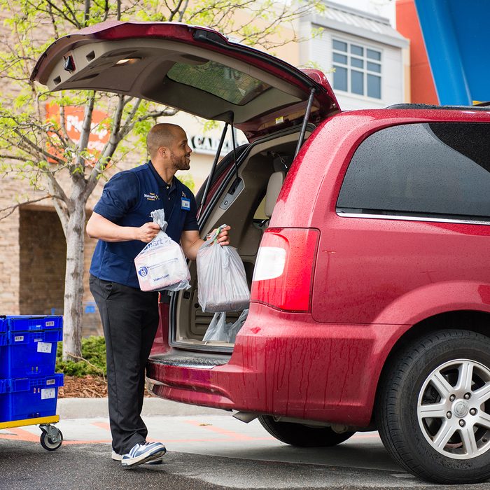 Walmart employee putting groceries into a customer's car