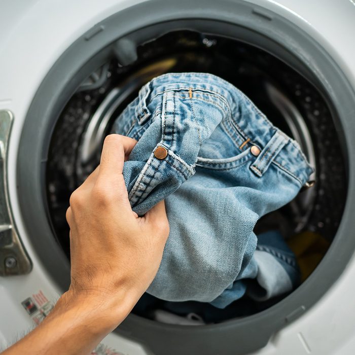 Putting jeans into the washing machine