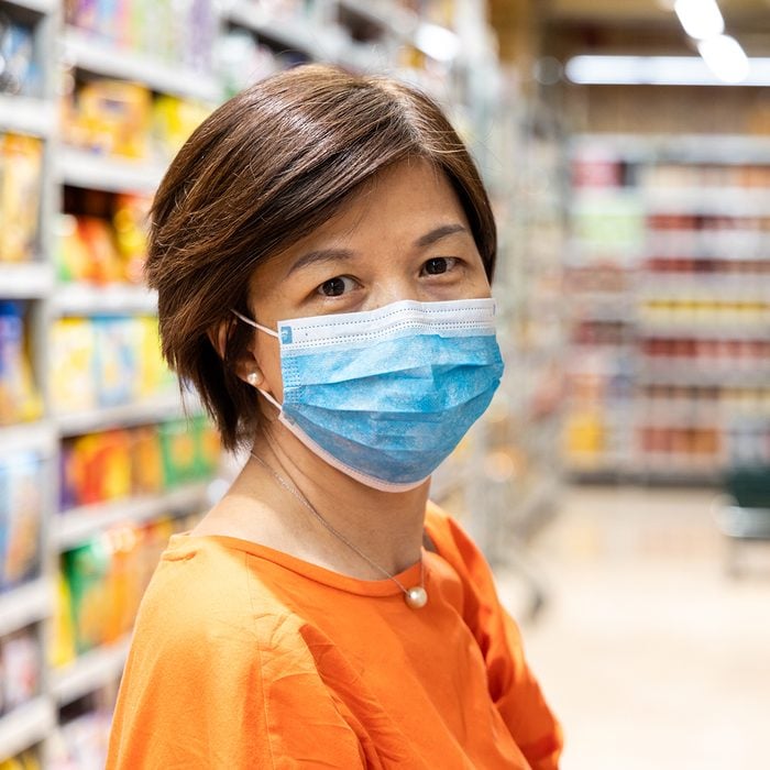 Asian women with face mask for protection against influenza virus shopping in supermarket