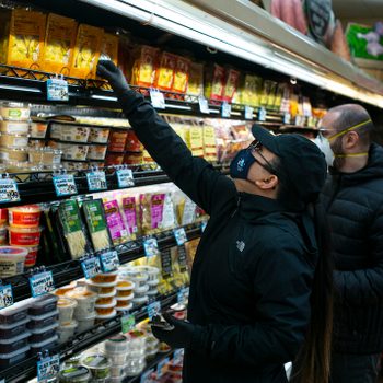 BROOKLYN, NEW YORK - MARCH 28: Shoppers wearing a surgical masks look at a prepared meals at a Trader Joes in Brooklyn, New York on March 28, 2020. The store lets in a minimum amount of shoppers at one time due to the spreading coronavirus. Trader Joes is an American chain of grocery stores headquartered in Monrovia, California. (Photo by Robert Nickelsberg/Getty Images)
