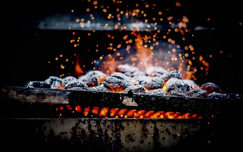 Close-Up Of Burning Coal On Metal Grill
