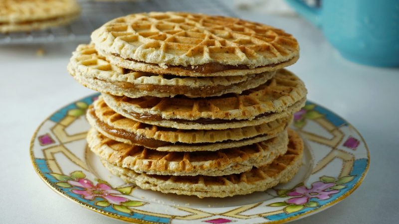 a stack of freshly made stroopwafels on a piece of china at an angle