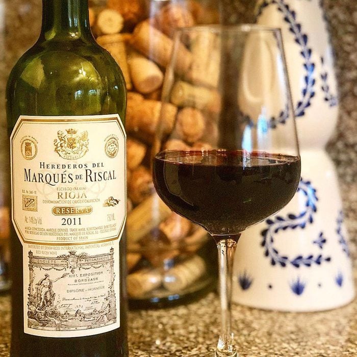 Marques de Riscal Rioja Reserva wine bottle with glass.