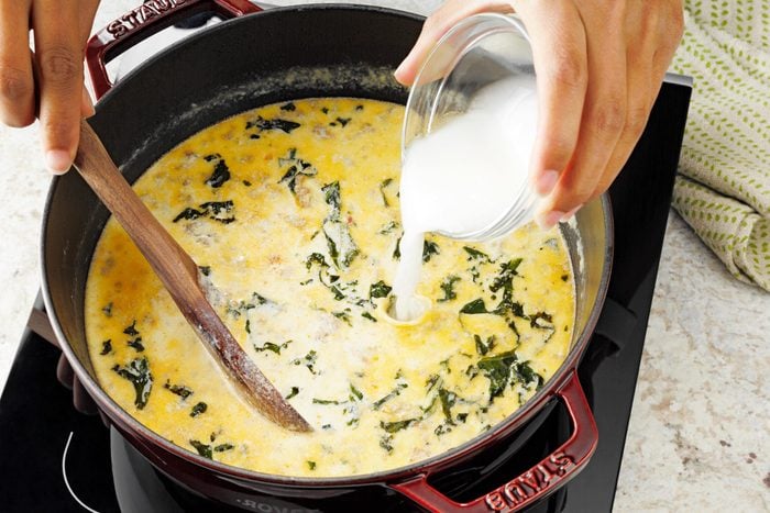 adding corn starch to pot of Zuppa Toscana