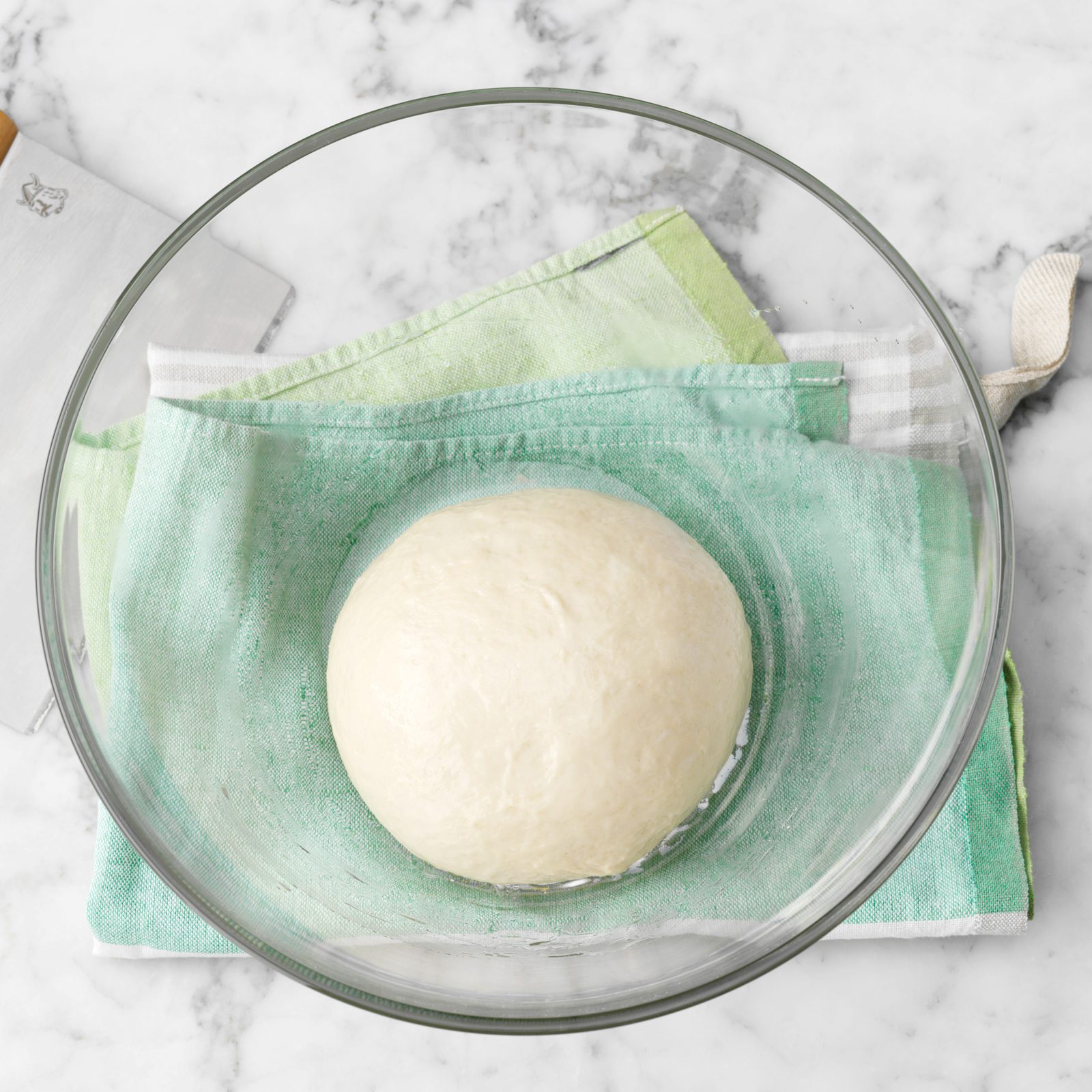 pizza dough ball in a glass bowl