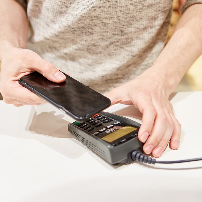 Customer at the checkout makes mobile payment with the smartphone