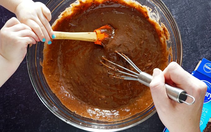 Mixing copycat Hostess cupcake batter with child