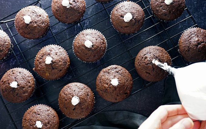 Injecting fluffy Hostess cupcake filling into baked cupcakes