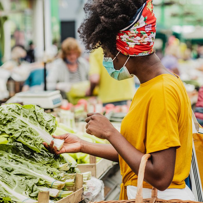 African American woman wearing a protective mask while buying groceries at the market