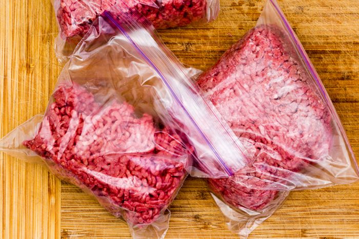 Fresh ground beef in resealable plastic bags ready to go into the freezer for storage on a wooden bamboo cutting board viewed from above with copy space; Shutterstock ID 507458869; Job (TFH, TOH, RD, BNB, CWM, CM): TOH