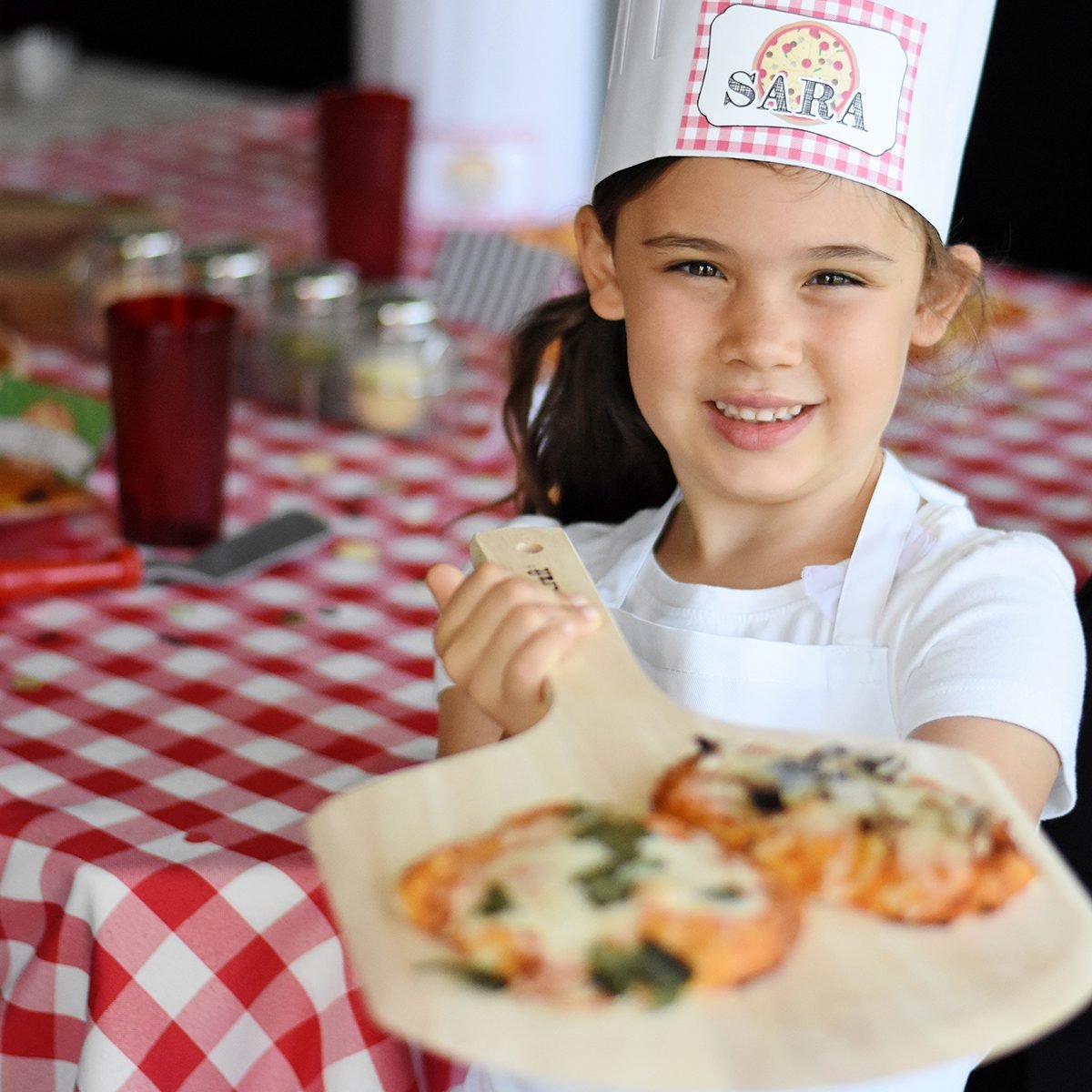jong meisje met pizza voor Pizza verjaardagsfeestje ideeën