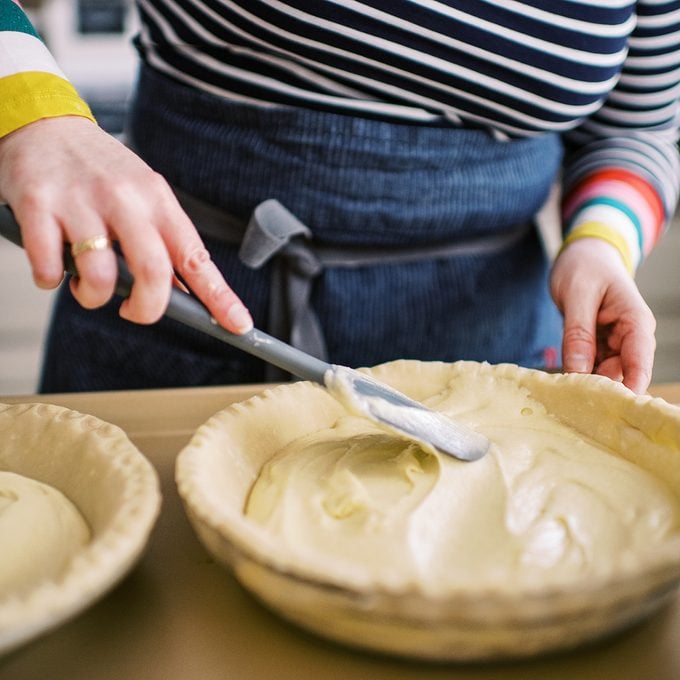 Spreading batter in pie crust with a knife