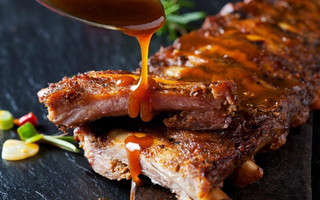 Barbecue sauce dripping on marinated and grilled spare ribs