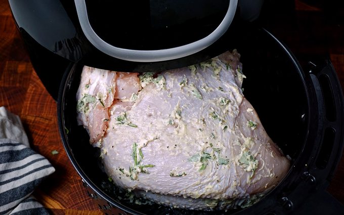placing the turkey breast into the preheated air fryer basket