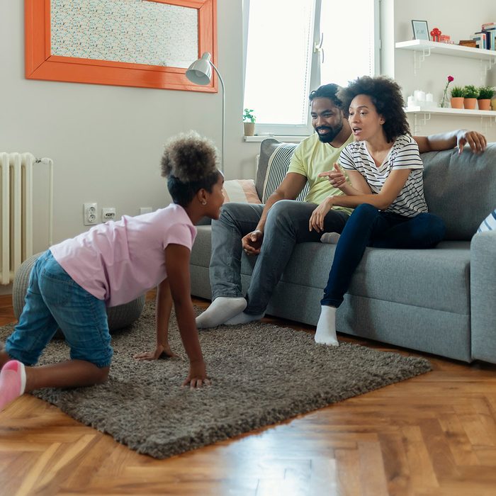 Young Parents and Their Daughter Are Having Fun and Playing Charades Together. Portrait of Happy Family Having Fun at Leisure. Entertainment Concept.