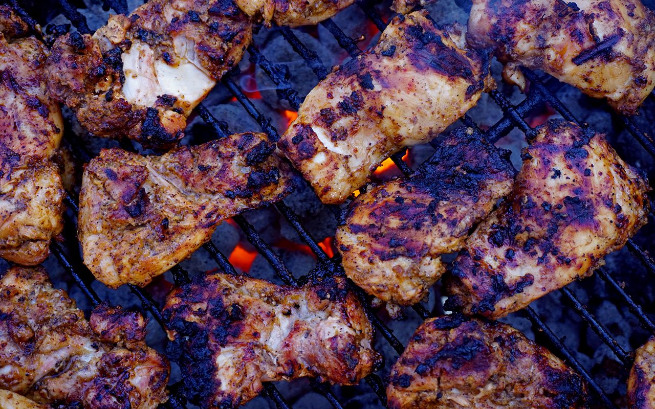 copycat chipotle chicken recipe being cooked on a charcoal grill