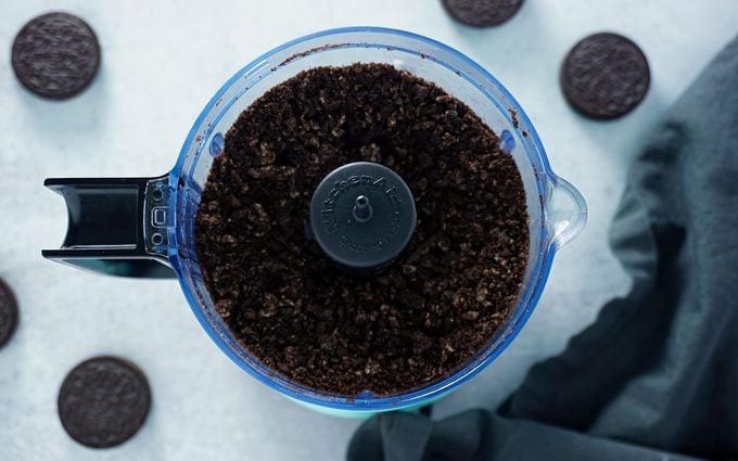 crumbled Oreos in food processor to make chocolate cookie crunch for homemade ice cream cake