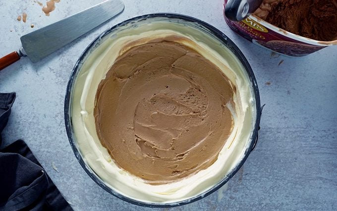adding chocolate ice cream layer to homemade ice cream cake