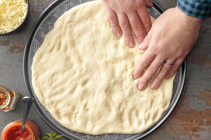 pressing pizza dough