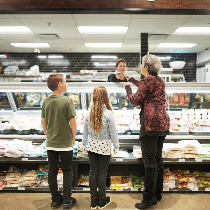Shot of a mature woman shopping with her grandchildren at a grocery store