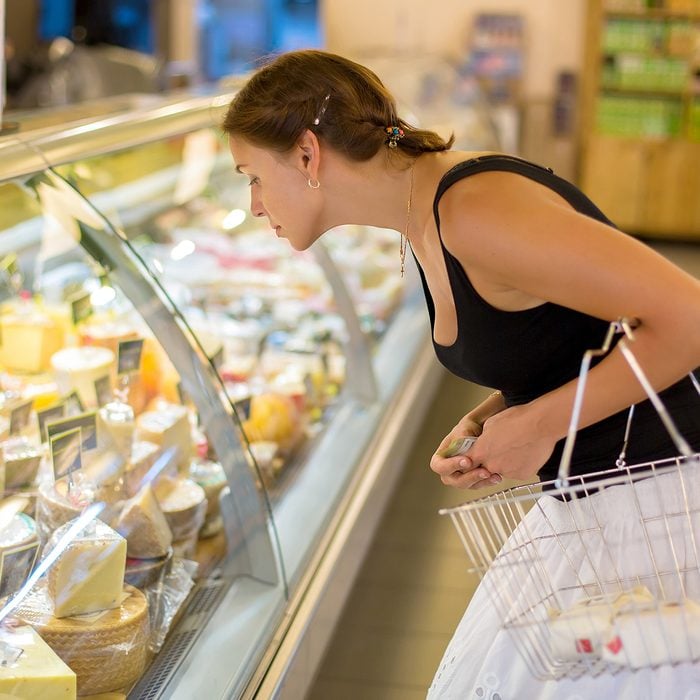 woman buys cheese in the supermarket