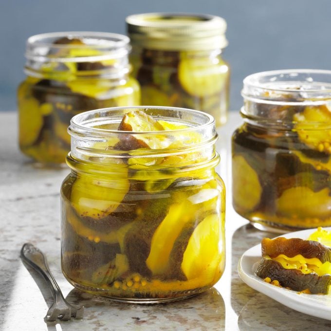 multiple jars of bread and butter sweet pickles on a kitchen counter