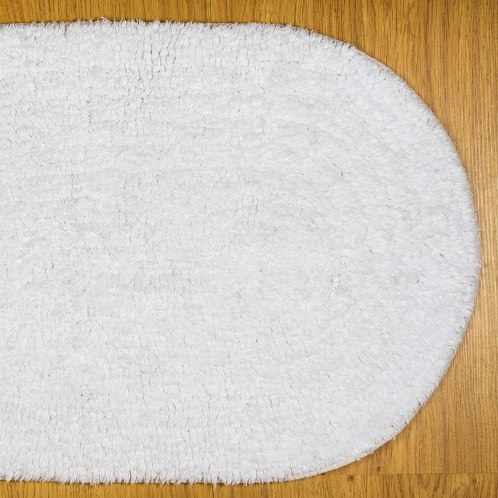 White bathmat over wood floor