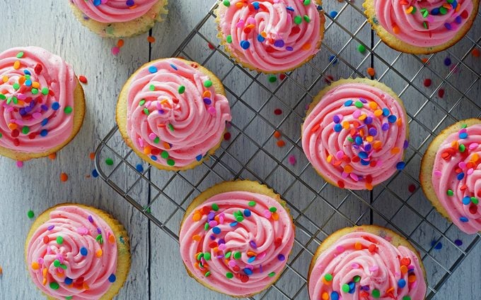 decorated birthday confetti cupcakes on cooling rack overhead