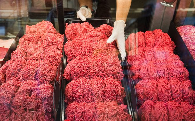 Hispanic butcher at meat counter of grocery store