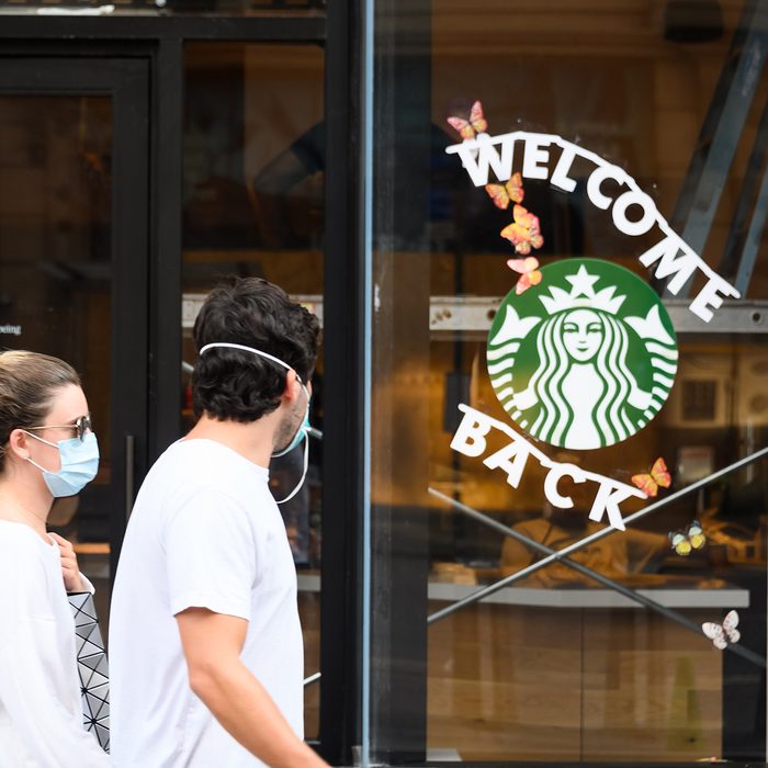 NEW YORK, NEW YORK - JUNE 23: People wear protective face masks outside Starbucks in midtown as the city moves into Phase 2 of re-opening following restrictions imposed to curb the coronavirus pandemic on June 23, 2020 in New York City. Phase 2 permits the reopening of offices, in-store retail, outdoor dining, barbers and beauty parlors and numerous other businesses. Phase 2 is the second of four-phased stages designated by the state. (Photo by Noam Galai/Getty Images)