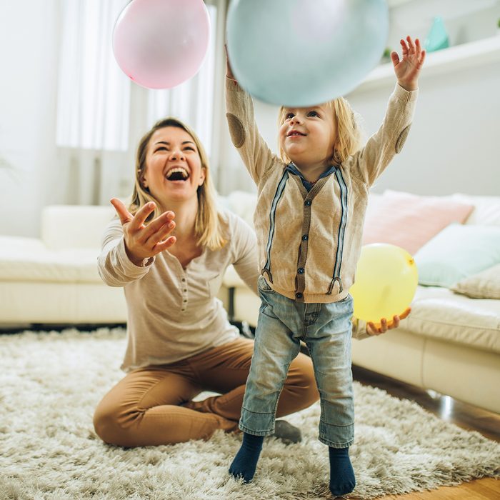 birthday party games for kids Happy mother and her small son playing with a balloons at home. Focus is on boy.
