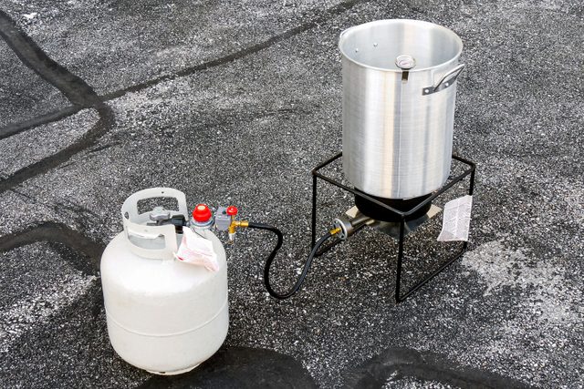 Propane Tank, Burner and Big Pot on Concrete Surface for Deep Fried Turkey