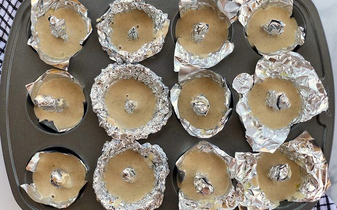 Muffin tin with doughnut foil inserts and batter