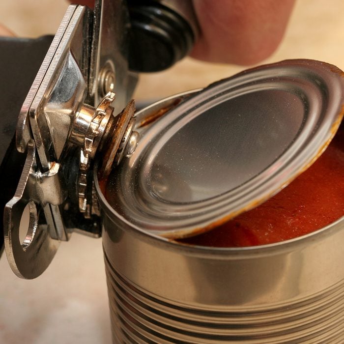 can opener opening can of tomato sauce