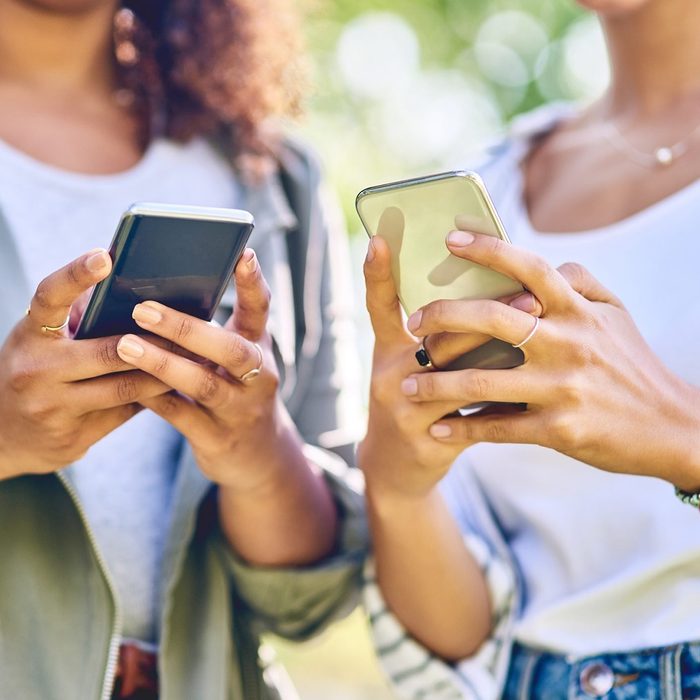 Cropped shot of unrecognizable women using cellphones outdoors