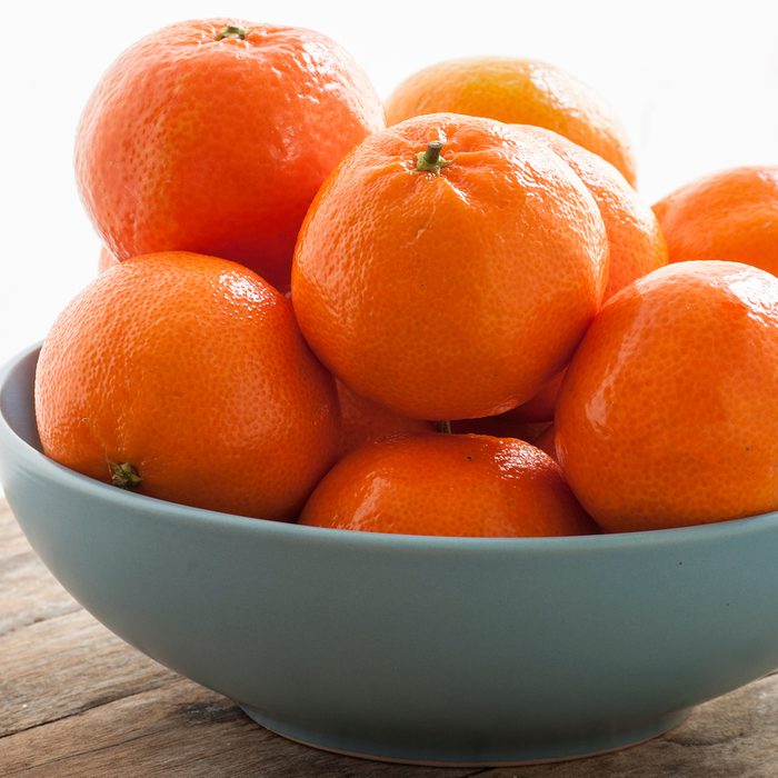 Close-Up Of Oranges In Bowl On Table Against White Background
