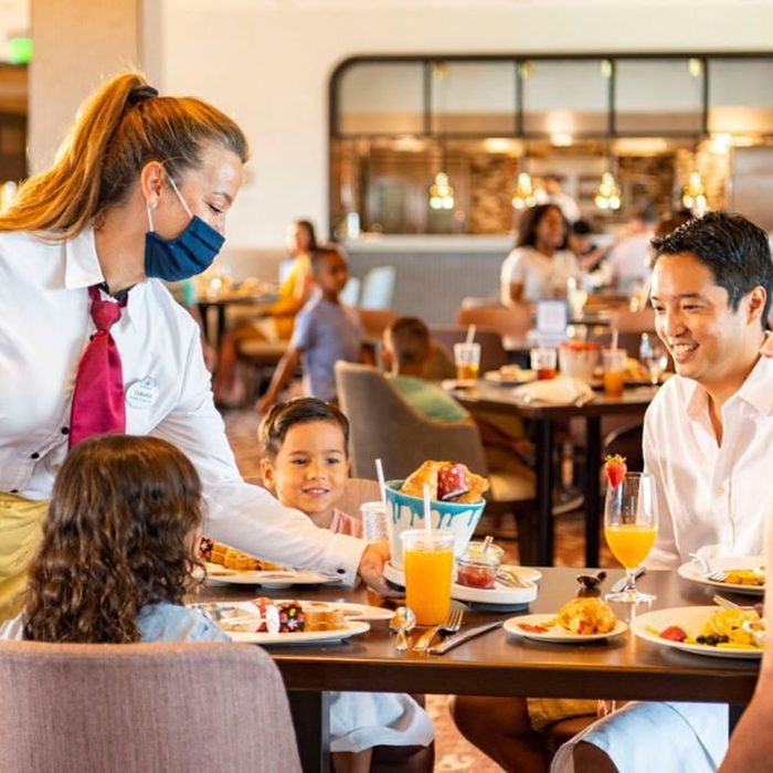 LAKE BUENA VISTA, FL - JUNE 23: In this handout photo provided by Walt Disney World Resort, new measures are in place to promote health and well-being in table-service restaurants at Walt Disney World Resort on June 23, 2020 in Lake Buena Vista, Florida. Cast members wear appropriate face coverings at all times, while guests can only remove their face coverings while sitting at their table. Walt Disney World Resort will reopen on July 11, 2020. (Photo by Matt Stroshane/Walt Disney World Resort via Getty Images)