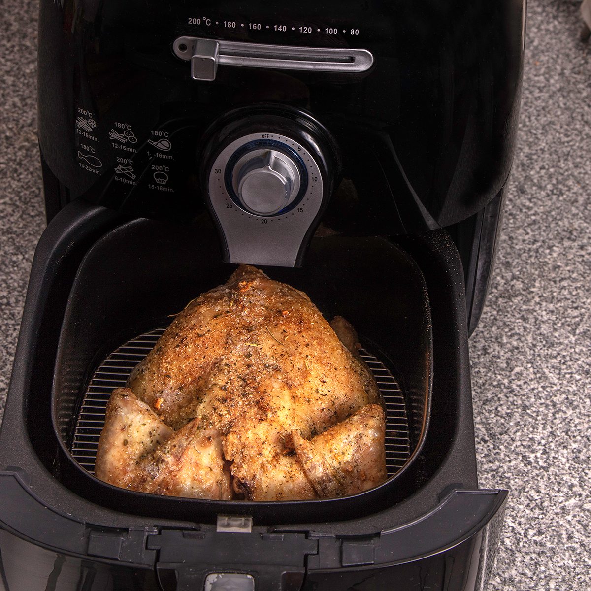 Roasted turkey in the hot air fryer / oven in the kitchen seen from above.