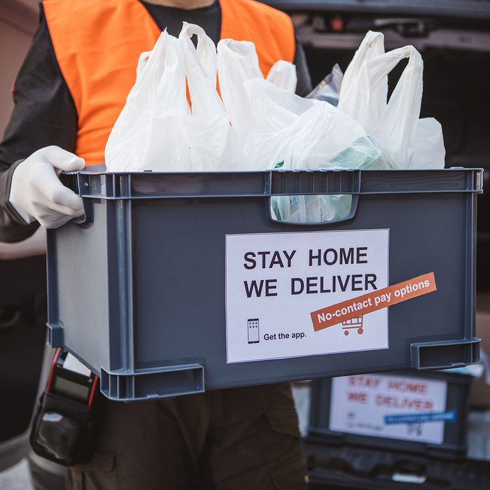 GROCERY SHOPPING ​ RE-IMAGINED​ Food Trends Report, Delivering food ordered online while in home isolation during quarantine. Stay home we deliver sign on box.