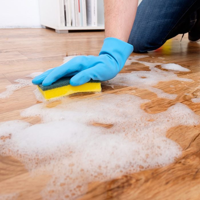 Cleaning a parquet floor with foam on the floor