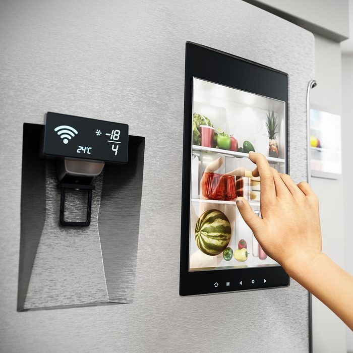 SMART KITCHENS ​ GET SMARTER​ Food Trends Report, Hand controls smart refrigerator interface with an image of the interior.
